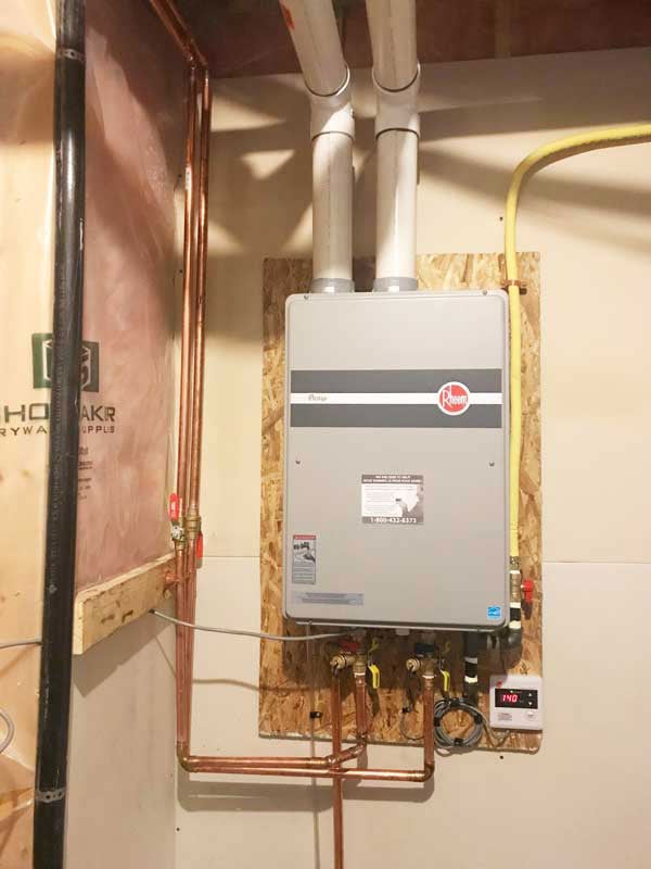 A tankless water heater installed in a bathroom by Hydro-Flo Plumbing & Heating in Edmonton, AB