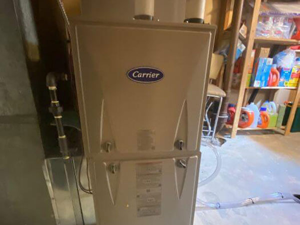 A gas furnace by Carrier situated in a garage in Edmonton, AB