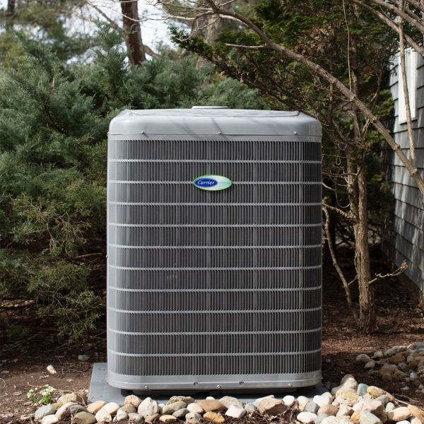 An Infinity system single AC unit heat pump situated in a backyard in Edmonton, AB