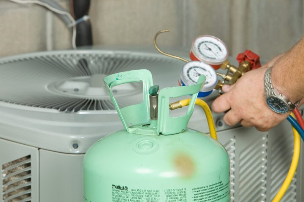 A Hydro-Flo Plumbing & Heating professional is installing  R32 refrigerant in Edmonton, AB.