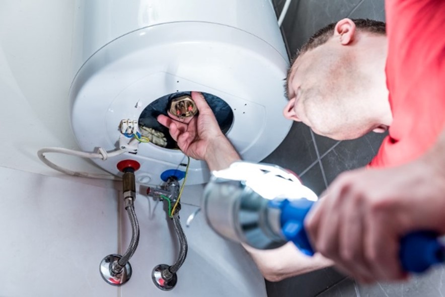 Technician performing maintenance inspection on a water heater