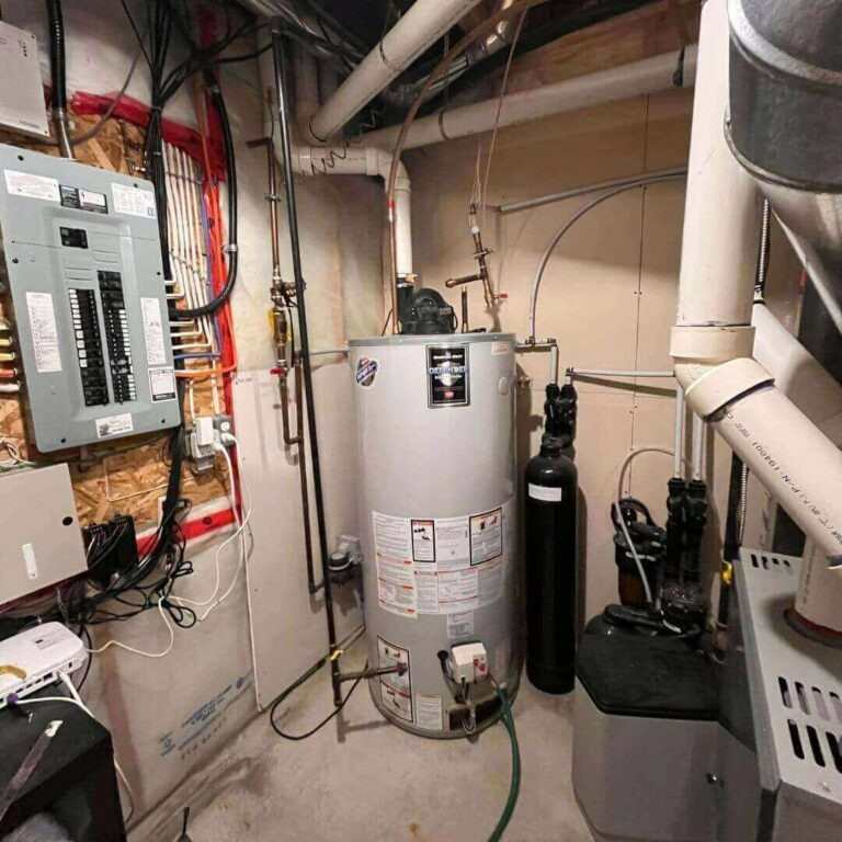 Water heater in a small room with pipes and electrical equipment in Edmonton, AB