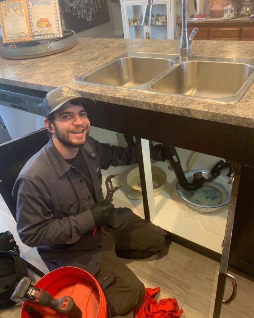 A Hydro-Flo Plumbing & Heating Drain Cleaning Tech Unclogging a Kitchen Sink in Edmonton, AB