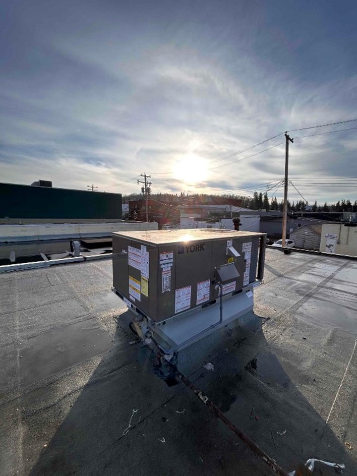 A commercial AC unit on a rooftop by Hydro-Flo Plumbing & Heating
