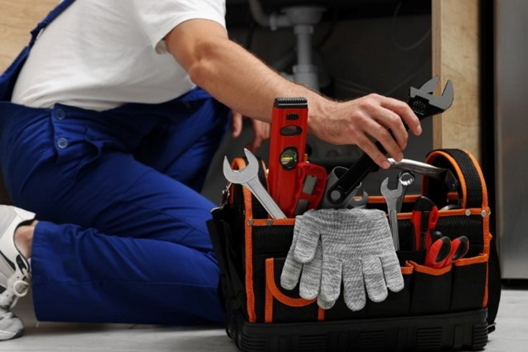 Close-up of plumber organizing tools in toolbox