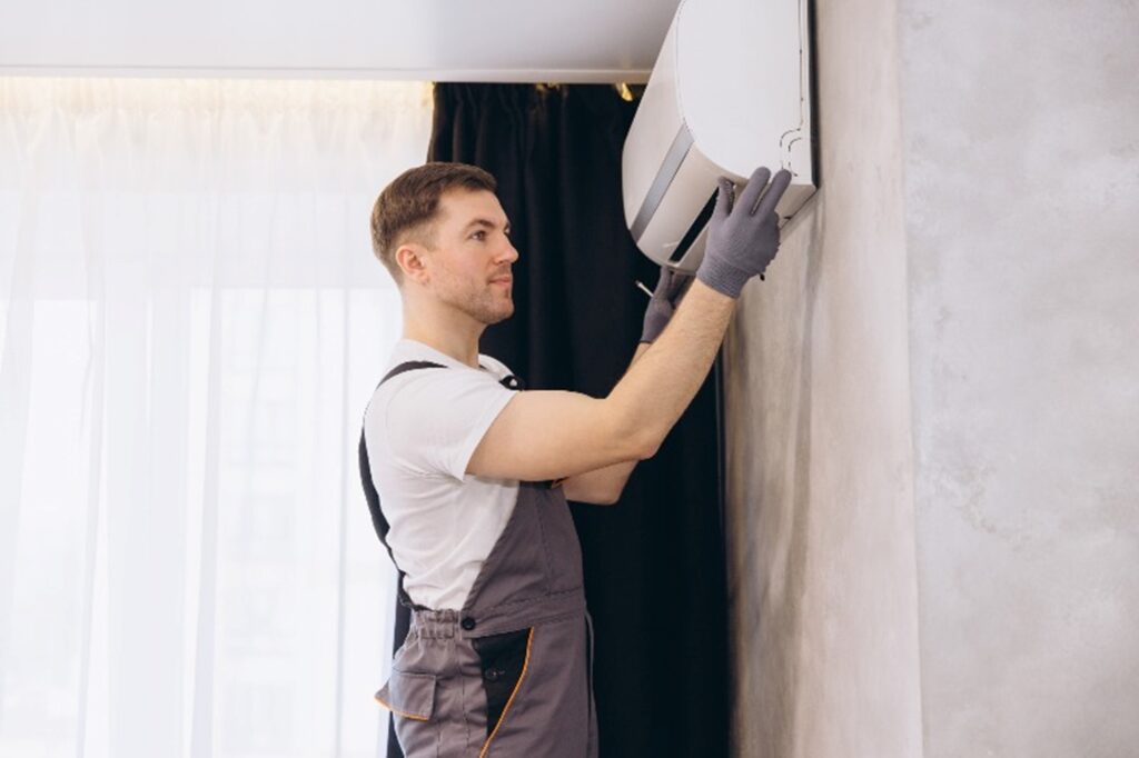 A man working on an air conditioning unit by Hydro-Flo Plumbing & Heating
